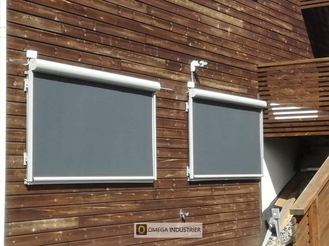 Gråe screens foran vinduer i brun trevegg