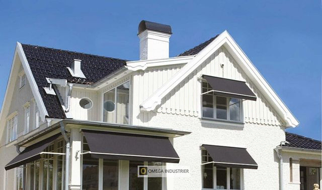 Hvitt hus med svarte markiser