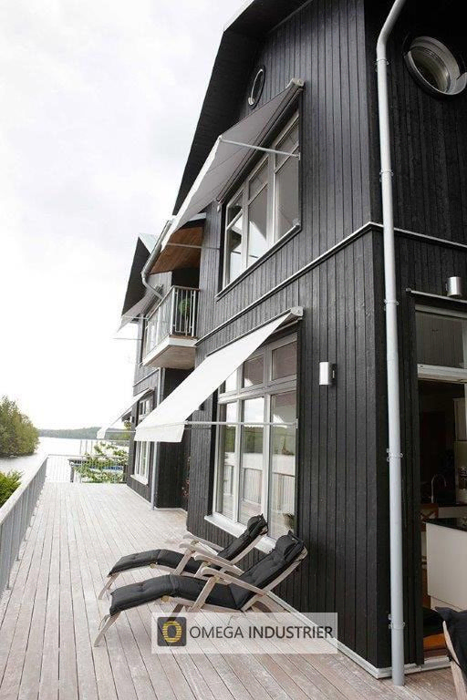 Svart hus med lyse markiser