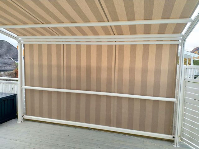Pergola med lyst, stripete stoff